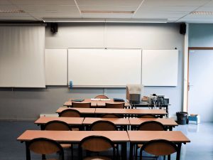 A classroom whiteboard and desks